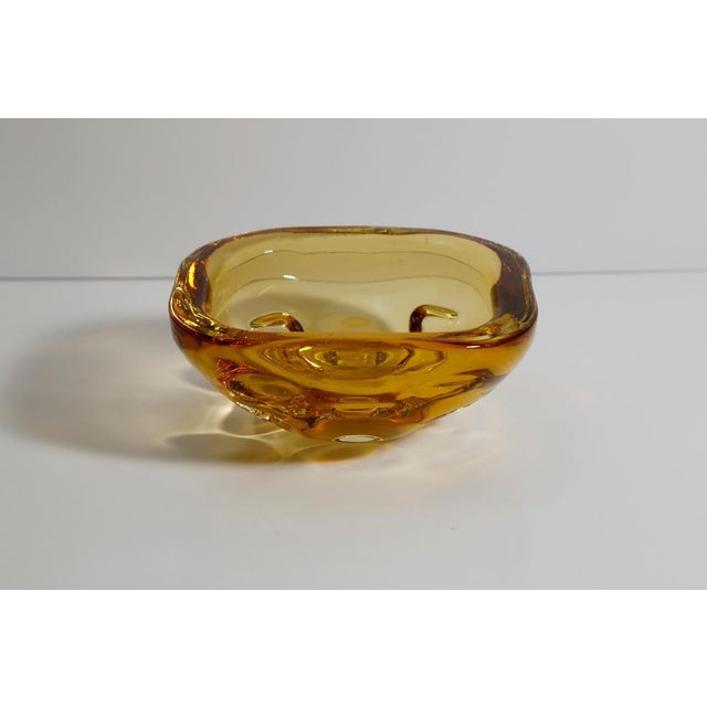 An amber Murano glass bowl by Galliano Ferro, hand-blown on Murano, Italy, during the 1960s. Thick-walled and sculptural,...