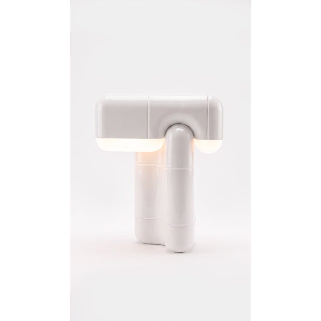 A table lamp that behaves like sculpture. Its folded, tile-built form reads as one continuous gesture, and when the light...