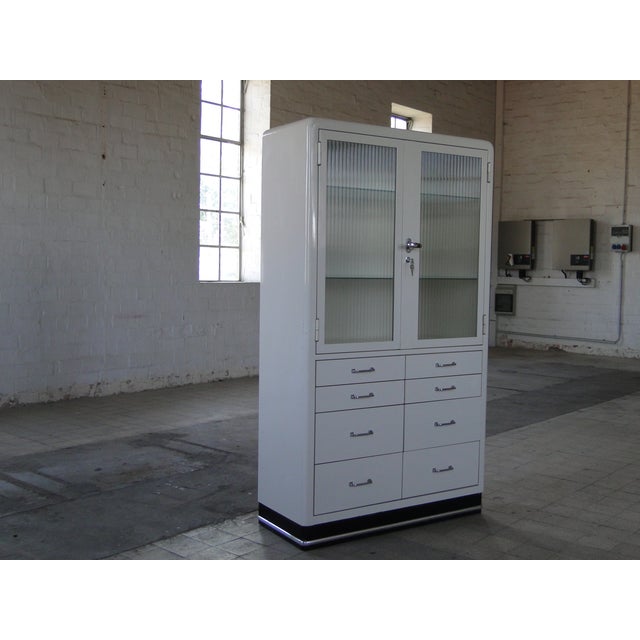 Classic metal medical cabinet by Baisch, this one in a rare version with many drawers. The upper section is a lockable,...
