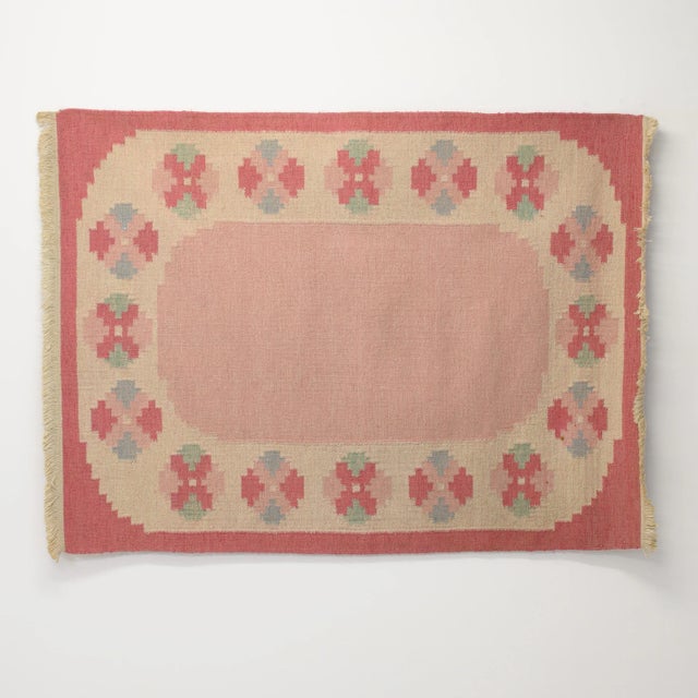 Mid-Century Swedish kilim in tones of pink and cream with a central plain area circled with medallions. Professionally...