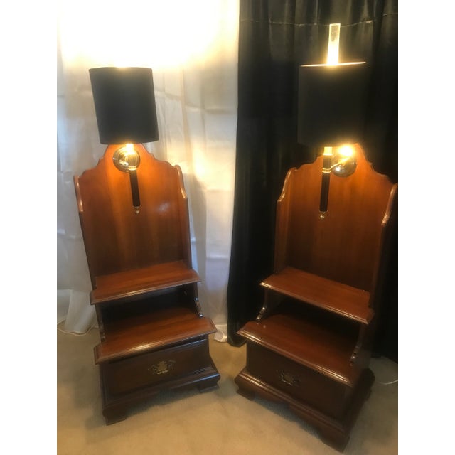 A pair of Willett Fine Furniture nightstands with torch style lights with black shades and golden interior. These...
