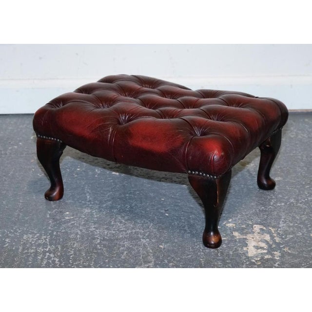 Vintage Burgundy Leather Chesterfield Footstool, featuring distinctive Queen Anne legs. This exquisite piece combines...