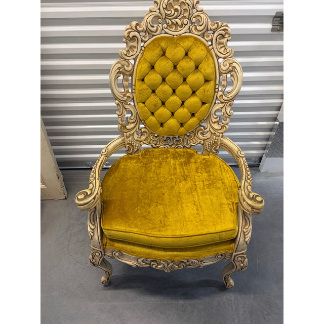 Elegant pair of vintage Rococo Revival armchairs featuring highly ornate carved wood frames with scrolling floral motifs,...