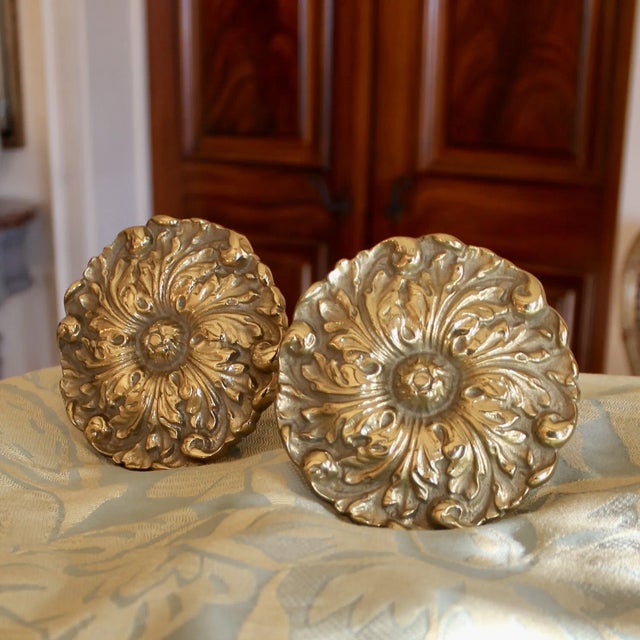 An elegant pair of substantial vintage brass tie backs cast in high relief. Rosettes are rendered with swirling petals...