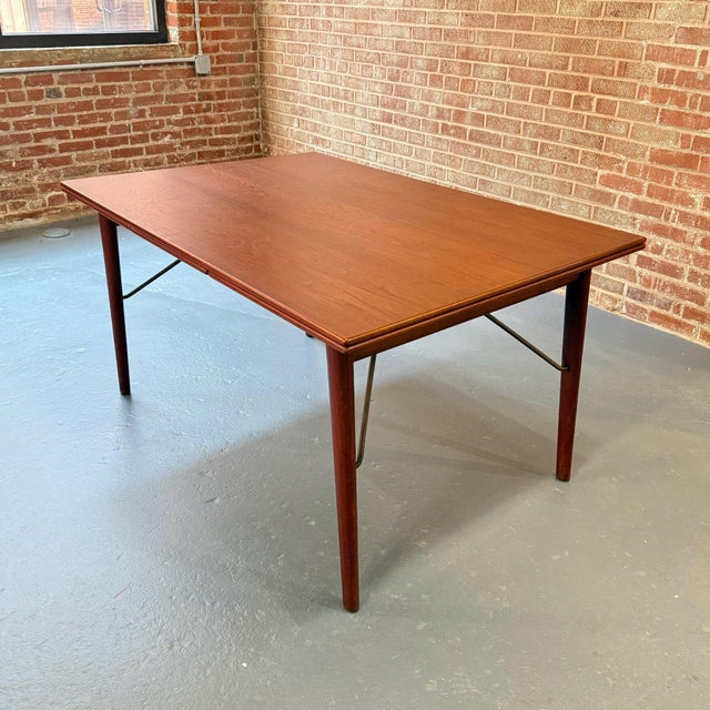 This teak Danish Modern dining table is in immaculate condition for it's age. The patina on the solid brass supports is...