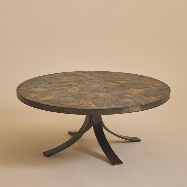 A French Brutalist round coffee table from the 1970s. The circular top is composed of laid slate tiles arranged in a...