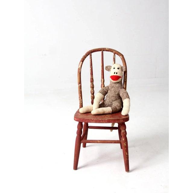This early 20th century vintage spindle back children's chair has a faded red to pink painted finish. Perfectly aged for...