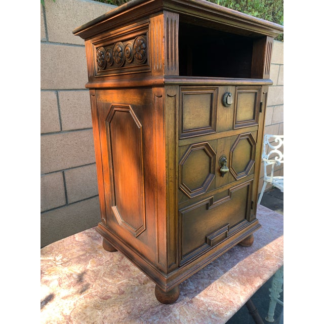 Here we have a very handsome antique carved Jacobean style side table or liquor cabinet. This one is made by Kittinger in...