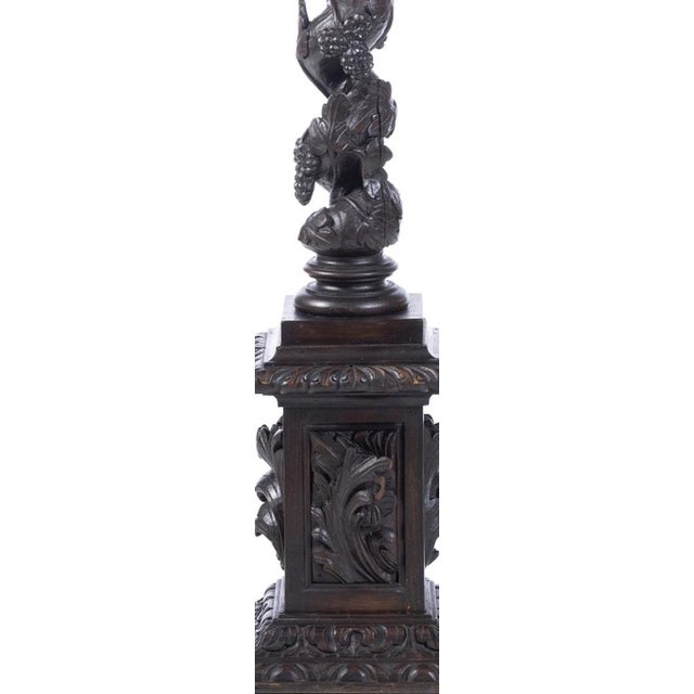 «Pair of columns. Portuguese, 20th century; carved chestnut wood decorated with vines and grapes. Height: 131x26x26 cm.»