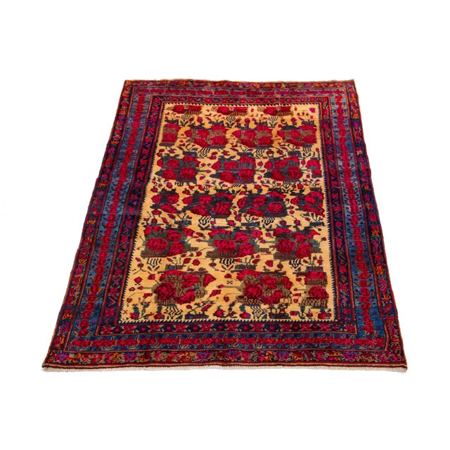 This hand-knotted Persian wool rug has a tan field with accents in red and blue all over the floral design. This rug...