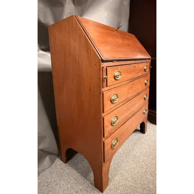 Early 19th century American cherry slant front bureau desk featuring a beautifully dovetailed case with four drawers below...