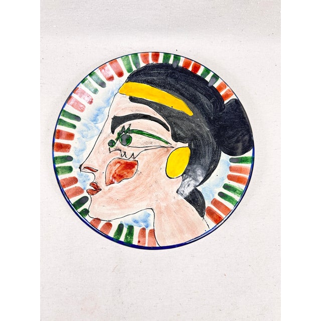 Bring a bold, artistic statement to your walls or tablescape with this striking terracotta glazed plate. Featuring a hand-...
