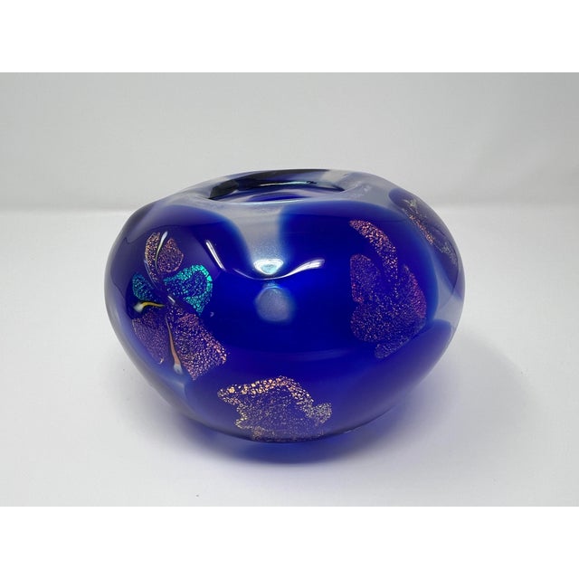 Hand-blown studio art glass vase in a rich cobalt blue hue, featuring shimmering iridescent metallic inclusions...