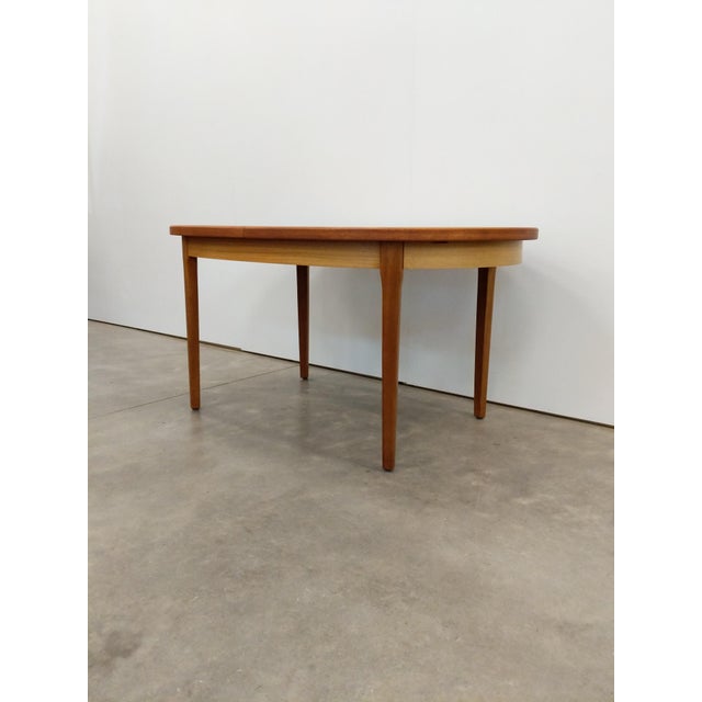 Authentic vintage mid century modern teak extendable dining table with built-in leaf. This piece is in excellent condition...
