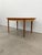 Authentic vintage mid century modern teak extendable dining table with built-in leaf. This piece is in excellent condition...