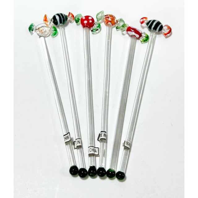 A whimsical set of six hand blown glass swizzle sticks topped with colorful wrapped candy forms in the style of Murano...