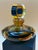 A striking vintage art glass perfume bottle featuring a sculptural, low-profile silhouette and a dramatic circular...