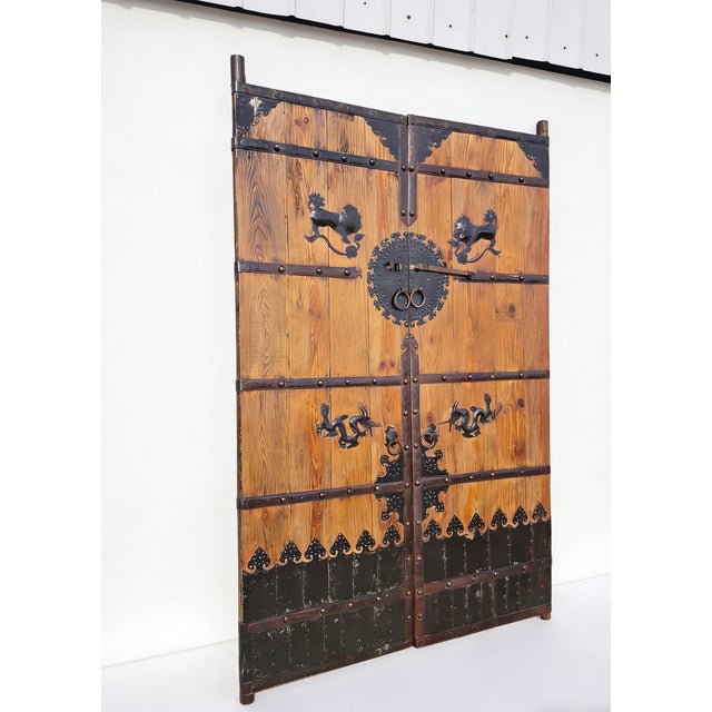 This pair of antique screen door panels showcase a blend of rustic pinewood and hand-forged artwork. Adorned with...