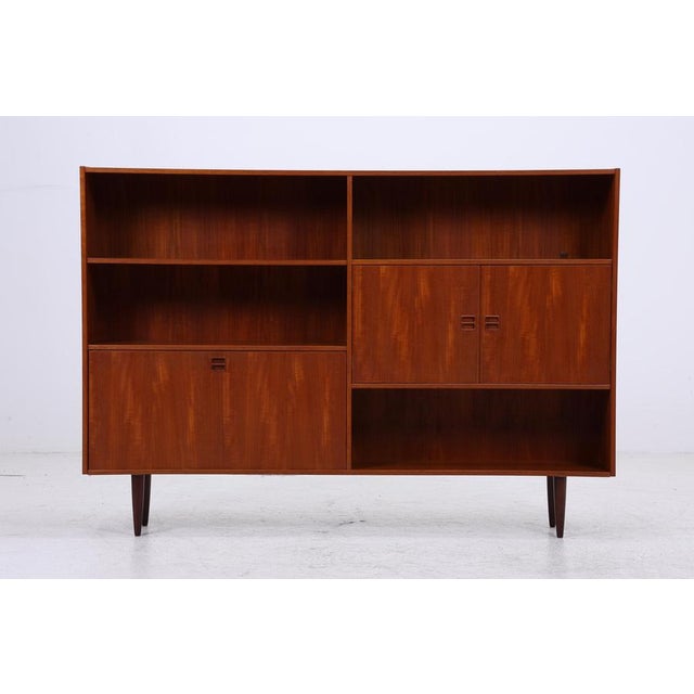 Beautiful vintage teak highboard from the 1960s with a clean, upright design and a calm, vibrant grain. Three doors, open...