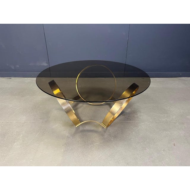 Space age era coffee table made from a sculptural brass frame and a smoked glass top. Attributed to knut Hesterberg Good...