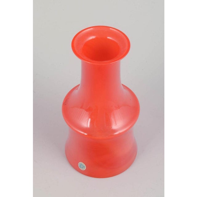 Swedish art glass Mouth-blown vase, 1970s. Mouth-blown vase in vivid orange glass with an elegant cylindrical body and...
