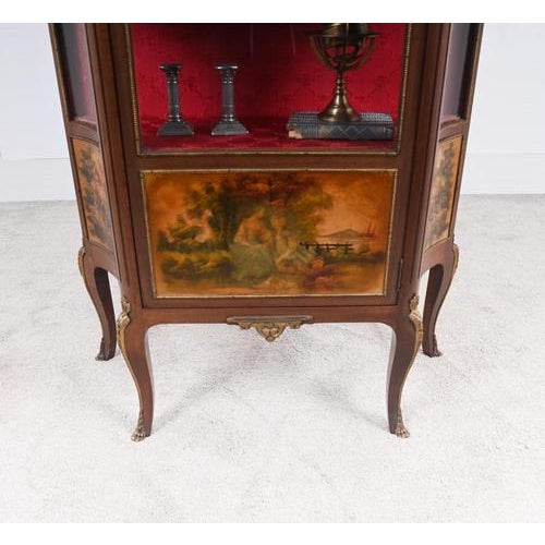 A decorative French kingwood vitrine cabinet dating to around 1900, richly mounted with ormolu mounts and topped with a...