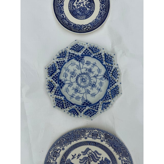 Set of three wall plates featuring blue and white Asian motifs, in graduated sizes. Does not include hangers. Two are blue...