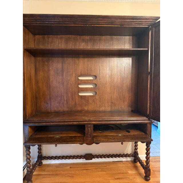 Elizabethan style dark oak linenfold TV cabinet with hinged fold-away doors, and an in-built infrared repeater system...