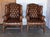 An exceptional pair of English Georgian-style wingback armchairs, embodying timeless British club sophistication and...