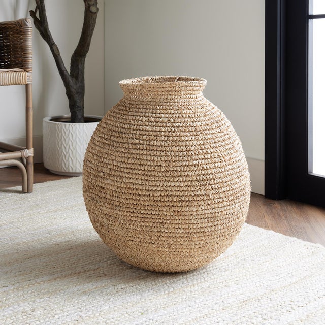 This traditional vase form takes on a fresh look. Made of a natural corn husk material tightly woven by skilled artisans....