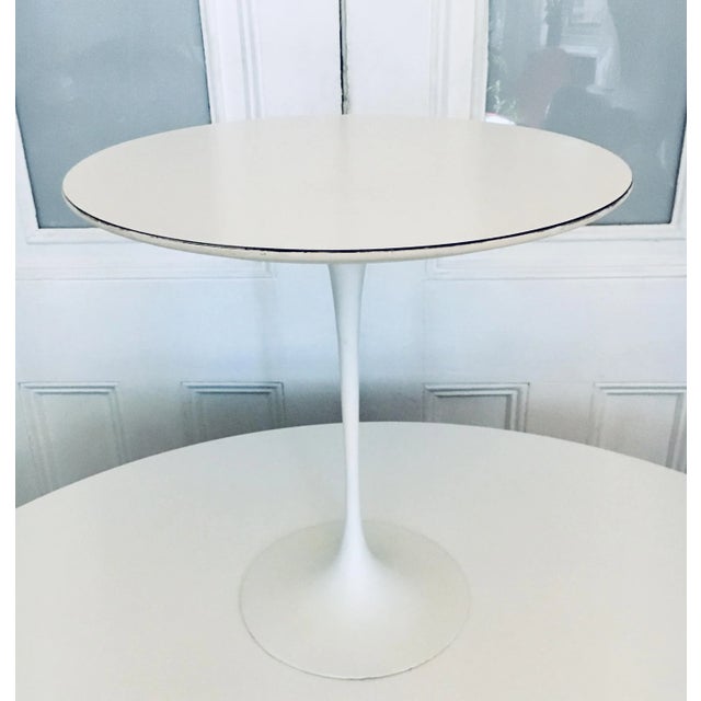Round 20" Tulip side or end table designed by Eero Saarinen for Knoll in 1956. Beveled white laminate wood top on white...