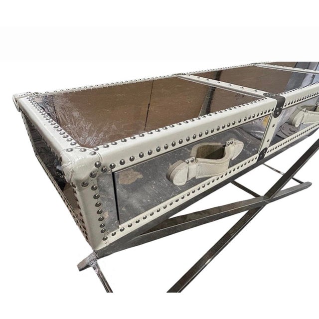 Console table with brushed iron X frame base and long rectangular case. Leather wrapped top with riveted trim and wood...