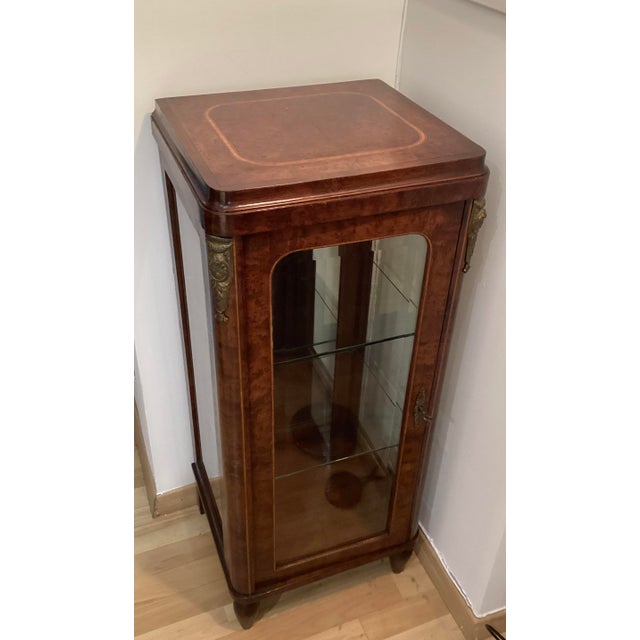 An elegant and well-balanced antique display cabinet in briar root wood, dating back to the late 19th century. The...