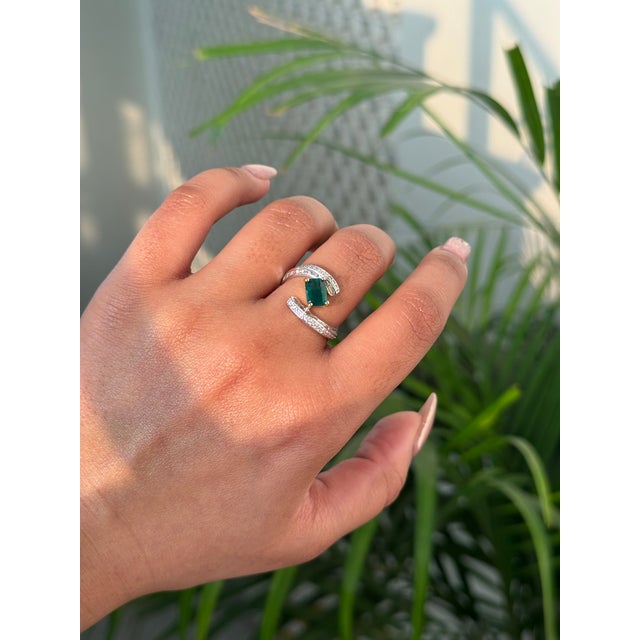 This striking 1.01 carat emerald-cut emerald and diamond contemporary bypass ring is crafted in 18K two-tone gold,...