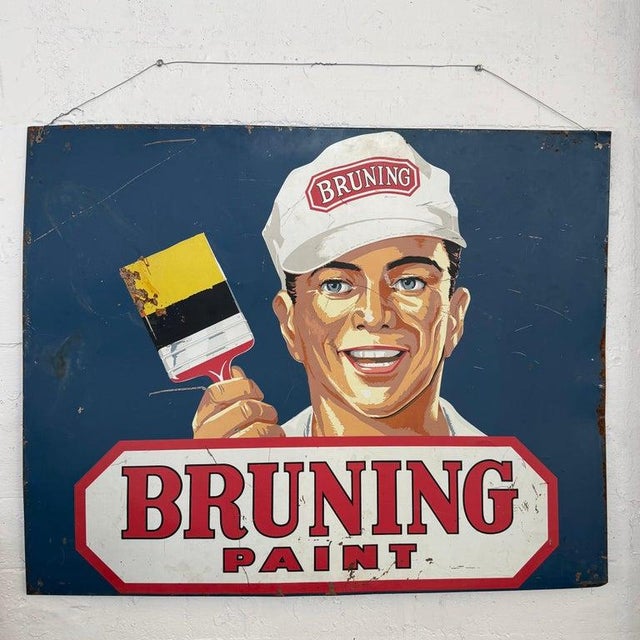 This large mid-century advertising sign for the Bruning Paint Co. established in 1923, features a smiling man wearing a...