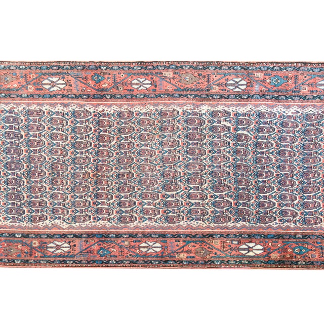 An exquisite early 20th-century Persian Nahavand rug featuring a dense, all-over paisley (boteh) pattern set within a...