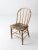 Antique spindle back chair from the 19th century featuring a graceful bow back silhouette and classic turned spindles. The...