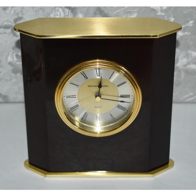 Vintage (1980's) Desk Clock has a MCM Style. Made by Bailey Banks and Biddle. The Clock is Battery Operated. The Wood is...