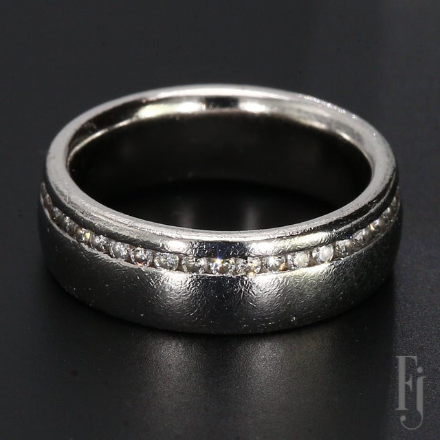 This is a textured platinum ring featuring an off-center row of forty channel-set round diamonds. Stone Information: 40x...