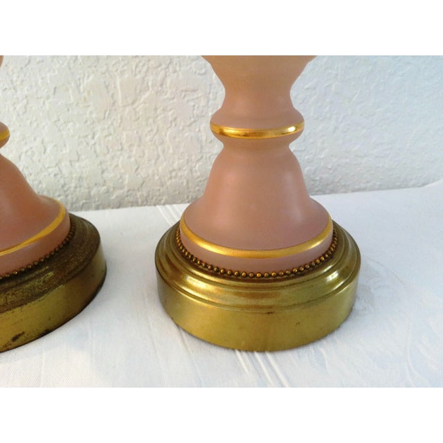 Pretty pair of light pink frosted glass lamps with brass bases. Frosted pink glass features a delicate hand-painted...