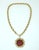 C.1970 Jomaz gold plated sunburst pendant necklace consisting of a red enameled pendant attached to a fluted chain link...