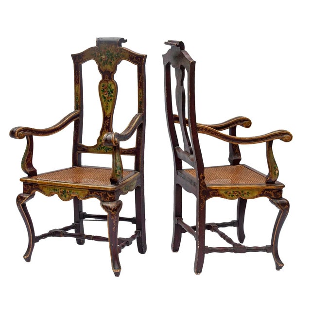 Venetian caned armchairs with fine floral painting. This pair features a shapely wood back with decorative top rail...