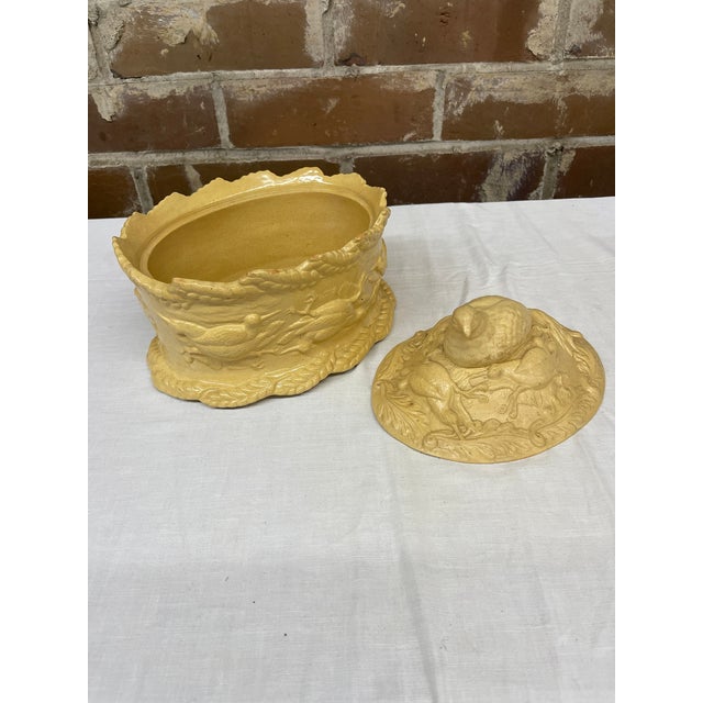 A 19th century English caneware game pie lidded dish with a bird (likely a pheasant or partridge) as the lid finial. There...