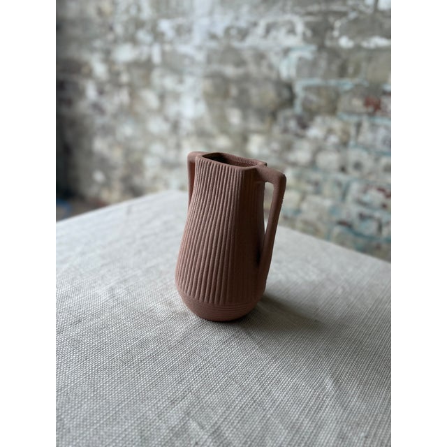 Add warmth and sculptural charm to your space with this beautiful small bud vase in a muted terracotta pink tone....