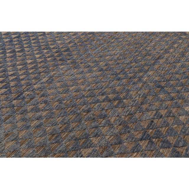 Made with hand-knotted wool, this 9x12 Moroccan rug in blue and brown features a contemporary approach to Berber tribal...