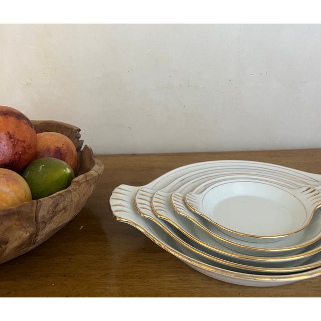 Set of five nested bowls made by L.L. Foëcy France around the 1940's. The white bowls have a hand painted gold trim....