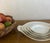 Set of five nested bowls made by L.L. Foëcy France around the 1940's. The white bowls have a hand painted gold trim....