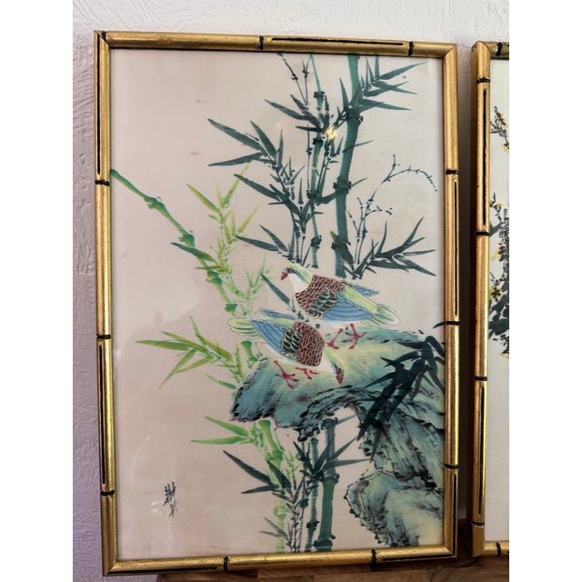 A beautiful pair of Japanese paintings on silk featuring graceful birds among blooming cherry blossoms and bamboo....