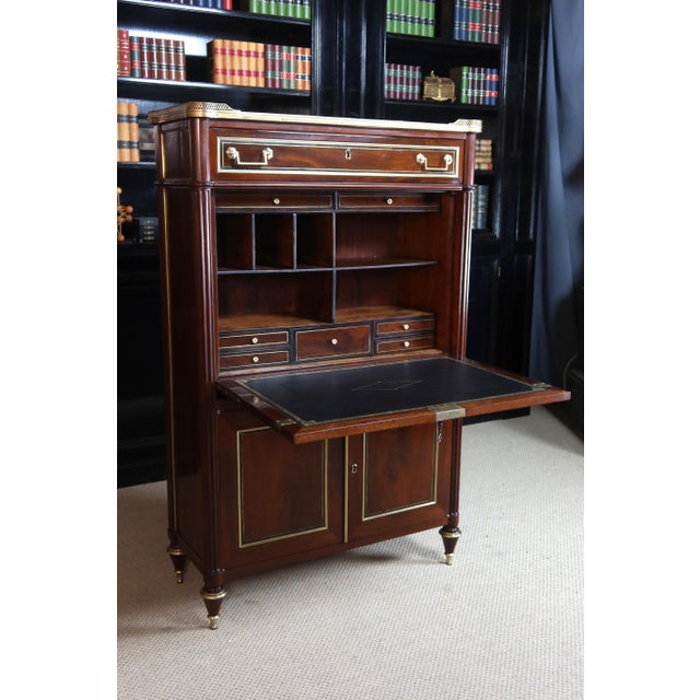 A Louis XVI secretary desk, late 18th century. This piece, with its rounded and fluted uprights, features clover-shaped...