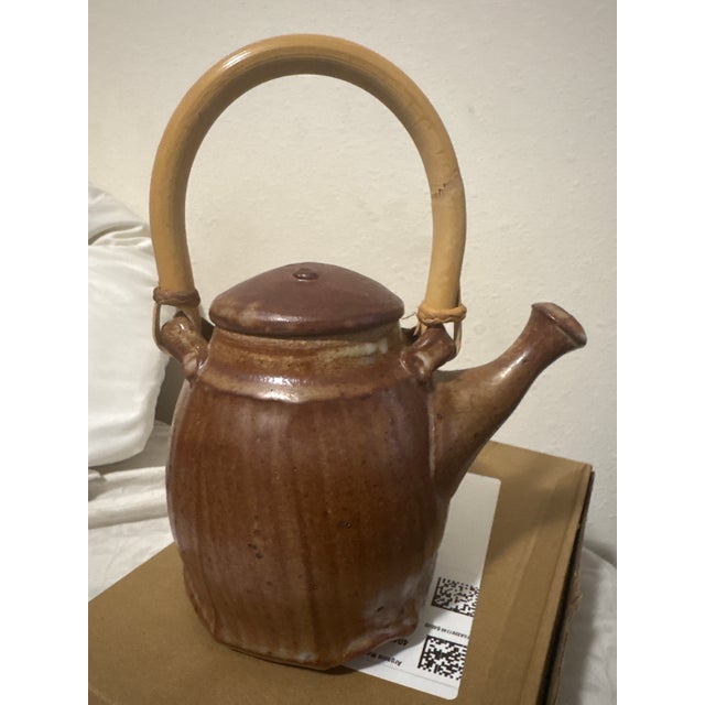 This vintage studio pottery teapot features a beautifully sculptural ribbed body finished in a warm iron-brown glaze with...